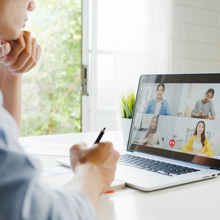 Man participating in a videoconference on his laptop