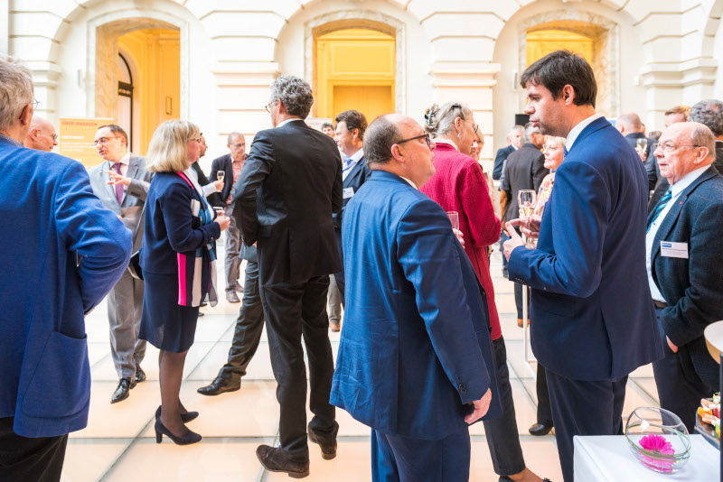 Picture of the atmosphere of the event where participants discuss over a drink.