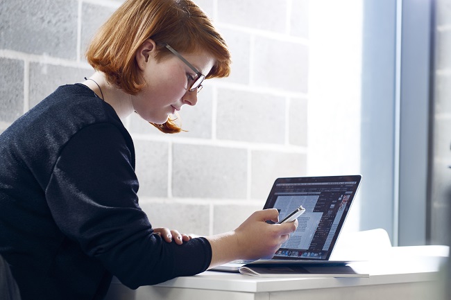 Student with a smartphone and a laptop